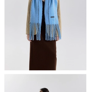 Detail of sky blue wool blend scarf with long tassels and branded woven label