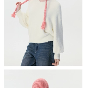 Detail showing high-quality pink knit earflap hat with decorative braided tassels