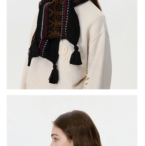 Detail of vintage Fair Isle knit scarf with ethnic geometric patterns and black tassels