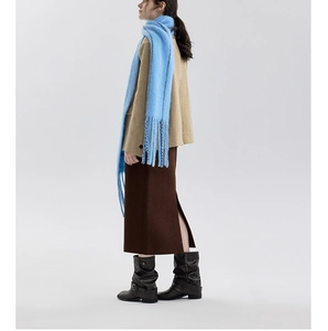 Detail of light blue wool blend scarf featuring long fringe tassels and soft plush texture