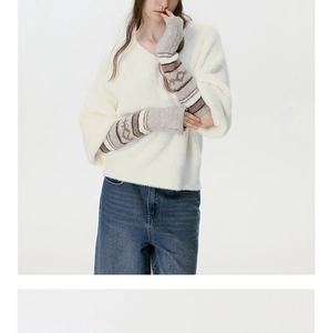 Dettaglio di scaldabraccia in maglia jacquard retrò con un maglione morbido con scollo a V