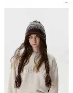 Détail d'un bonnet en maille rayé chaud avec glands et une texture douce en mohair