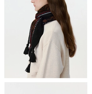 Detail of winter knit scarf with red and brown Fair Isle pattern and black fringe tassels