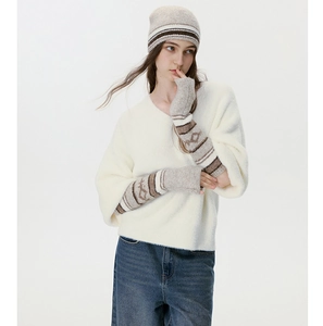 Dettaglio della maglia del maglione bianco con berretto a righe e manicotti abbinati