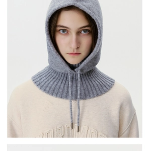 Detailed texture of light gray knitted balaclava with thick ribbed hem and drawstrings