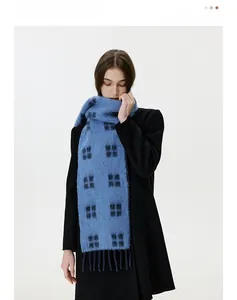 Detailed view of the soft plaid knit scarf texture and vibrant blue fringe detail