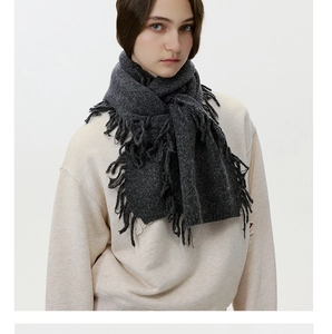 Detailansicht eines dunkelgrauen Strickschals mit langen Fransen und warmer Wolltextur