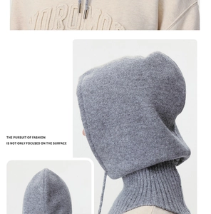 Detail view of gray knitted balaclava with soft wool texture and embroidered sweatshirt