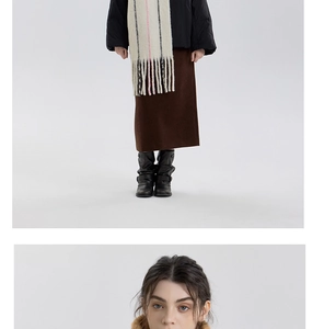 Close-up of a striped wool tassel scarf paired with a black jacket and wool skirt