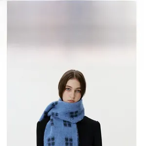 Detailed texture of blue checkered wool scarf with soft fringe and plaid pattern design