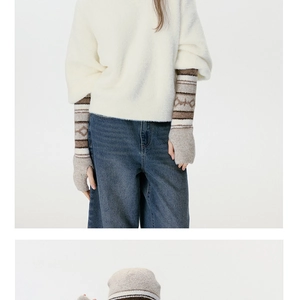 Dettaglio di manicotti lunghi in maglia jacquard con motivi geometrici a onde