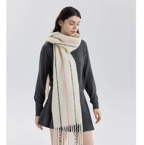Close-up of wool blend knit scarf featuring pink stripes and soft fringe details