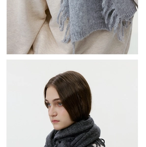 Detailaufnahme der weichen Fransen und des strukturierten Strickstoffs am Winterschal