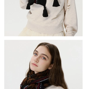Detailed view of Fair Isle pattern knit scarf with fringe textures and warm wool fabric
