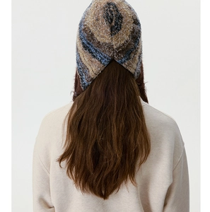 Vue arrière du bonnet en tricot avec texture marbrée douce et détails de glands tressés