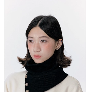 Detail of black knitted neck warmer with side button accents on a soft wool blend