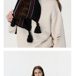 Detail of vintage Fair Isle knit scarf with geometric pattern and thick black tassels
