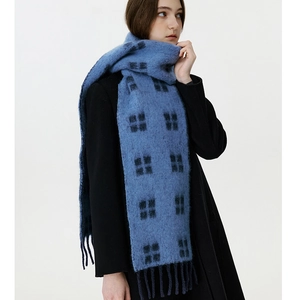 Detail of soft wool plaid scarf in deep blue with thick texture and long fringes
