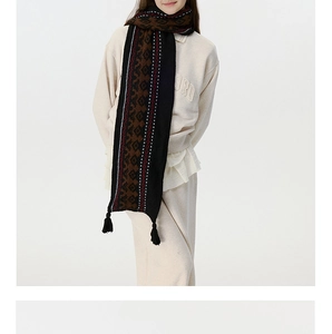 Detail of vintage Fair Isle knit scarf featuring geometric patterns and black fringe trim