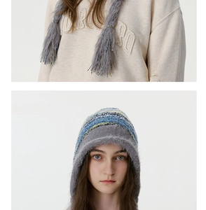 Détail du bonnet en tricot rayé coloré avec de longs glands en peluche et doublure