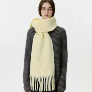 Weicher gelber Fransenschal mit Perlen-Bogenstickerei über grauem Strickpullover