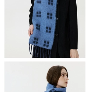 Detail showing soft wool blend texture and fringe of a blue checkered winter scarf