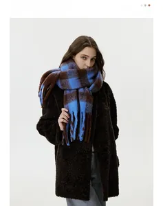 Detail of blue and brown checkered scarf with long fringe tassels and plush texture
