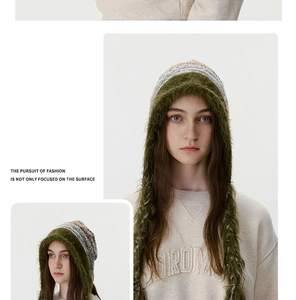 Détail du bonnet en tricot avec cache-oreilles, longues franges et bord en fausse fourrure
