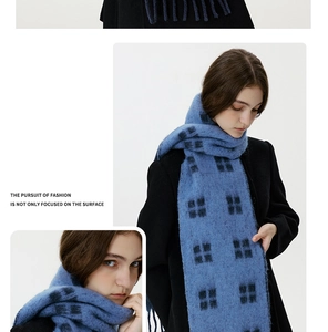 Close-up of blue plaid wool scarf featuring soft texture and classic fringe details