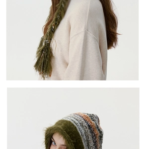 Détail d'un bonnet en tricot rayé avec bordure en fausse fourrure verte et écharpe