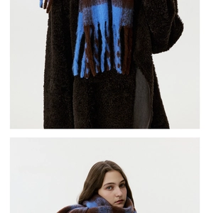Detail of blue and brown checkered scarf featuring thick woven texture and long tassels
