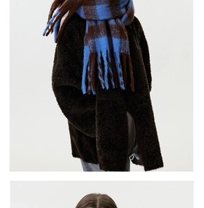 Detailed texture of blue and brown checkered cashmere-feel scarf with long fringes