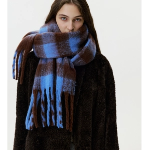 Close-up of thick checkered scarf in blue and brown with soft tassels detail