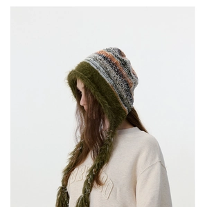 Vue détaillée du bonnet en tricot avec bordure en fausse fourrure verte et rayures