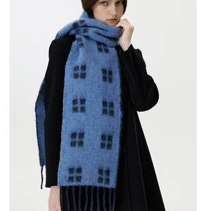 Close-up of soft plaid wool scarf with blue and black patterns and fringe tassels