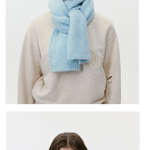 Close-up of light blue thick wool knit scarf with soft mohair texture and layered styling