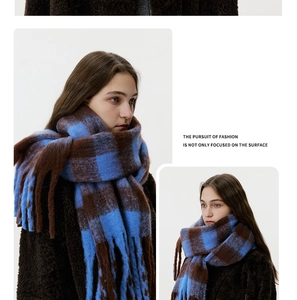 Detail view of thick checkerboard scarf with long fringes and soft wool-like texture
