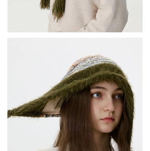 Détail de la bordure en fourrure verte et du tricot rayé sur le bonnet oreilles d'elfe