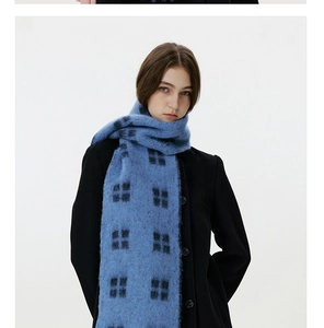 Close-up of soft navy blue plaid wool scarf with thick fringe and knit texture