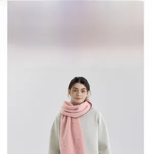 Close-up of pink knit scarf with black contrast stitching and soft textured fabric