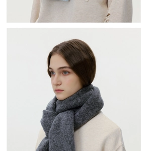 Detail of soft dark grey wool knit scarf worn in a classic wrap style for winter
