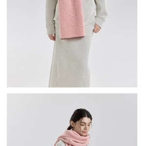 Detail of pink thick faux cashmere scarf with stitching edges on grey knitwear outfit