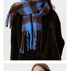 Detail of blue and brown checkered scarf with soft faux cashmere texture and long fringes
