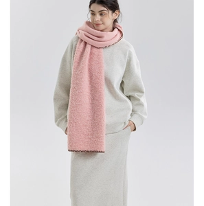 Detail of pink cashmere-like scarf showing thick brushed texture and dark wavy stitched edges