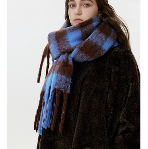 Detail of checkered cashmere-feel scarf with blue and brown patterns and long fringes