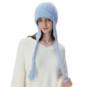 Cozy light blue cable knit earflap hat with long braided tassels for winter warmth
