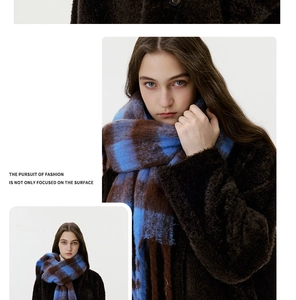 Detail of blue and brown checkered scarf with fringe tassels on plush faux cashmere fabric