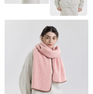 Detail of pink cashmere-like scarf showing warm wool texture and brown stitched edges