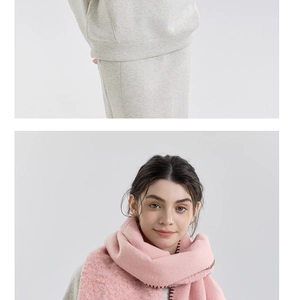 Close-up of pink cashmere-like scarf with brown stitching over a gray knit set