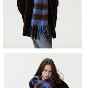 Close-up of blue and brown checkered scarf with fine fringe details on a plush jacket